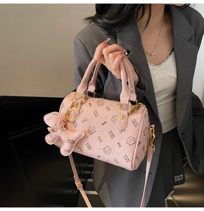 Detail of pink Boston bag with cute cat prints and a decorative bear charm