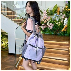 Detail view of purple drawstring backpack with a heart shaped mesh pocket and grey accents