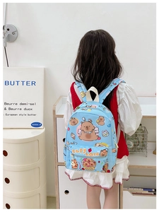 Detail of children's blue checkered backpack with cute Capybara print and large front pocket