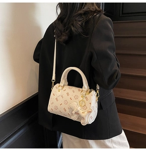 Chic cream Boston bag with cat print shown on model in a stylish indoor setting