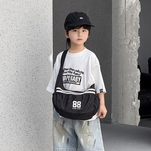 Détail du sac bandoulière de sport noir avec imprimé 88 blanc et texture en nylon