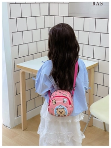 Pink cartoon capybara print mini shoulder bag shown on child for size reference