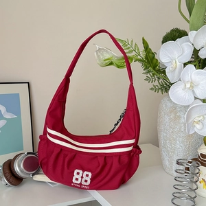 Détail du sac de sport rouge avec rayures blanches et chaîne décorative noire