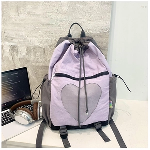 Detail of a purple drawstring backpack with a large heart-shaped mesh pocket for campus use