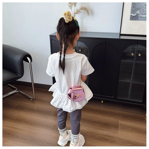 Vista posteriore di una borsa a catena rosa metallizzata con fiocco d'oro su una bambina