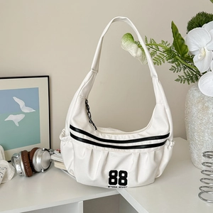 Détail d'un sac bandoulière en toile blanche avec rayures noires et le numéro 88