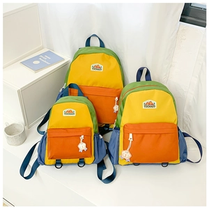 Three sizes of colorful block nylon kids backpacks with mountain logo and circular charms