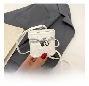 Detailed macro of cream white pebble leather mini bucket bag with silver metal zippers