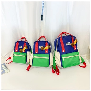 Trois tailles de sacs à dos pour enfants color-block en bleu et vert avec breloques