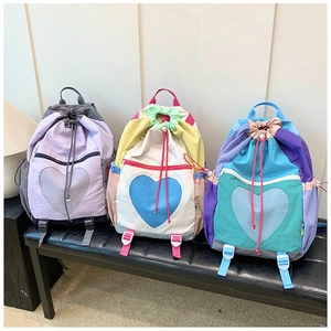 Detailed view of colorful drawstring backpacks with heart patterns and nylon fabric