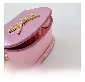 Macro di mini borsa rosa metallizzato con fiocco dorato e dettagli di cucitura
