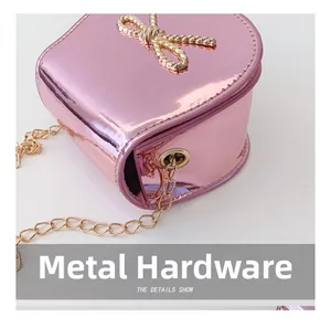Dettaglio della borsa a cuore rosa metallizzato con fiocco dorato e occhielli in metallo