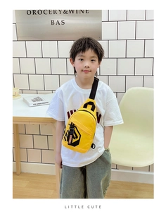 Close-up of yellow nylon kids chest bag with adjustable black strap and brand print