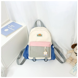 Close-up of kids backpack with colorful patchwork, brand patch and medal accessory