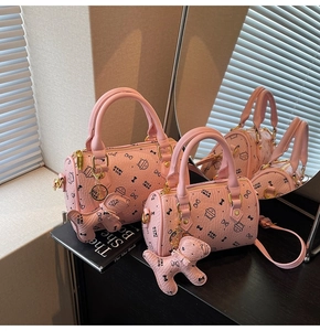 Detailed view of pink barrel bags with cute cartoon prints and puppy charm accessory