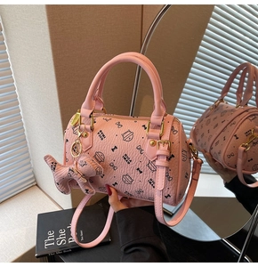 Detailed close-up of a pink boston bag with cute cat print and golden hardware accessories
