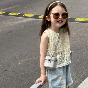 Detail view of mini silver cylinder crossbody bag with dual metal zippers for kids