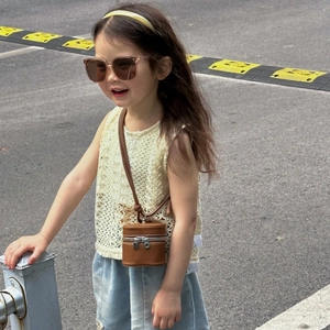 Mini brown leather bucket bag for girls paired with stylish summer outfit in outdoor setting