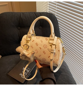 Detail of white cat-print boston bag with litchi texture and golden hardware