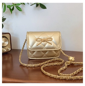 Detailed view of quilted girl's mini bag with gold chain strap and bow metal clasp