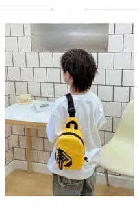 Rear view of a child wearing a bright yellow canvas chest bag with adjustable strap