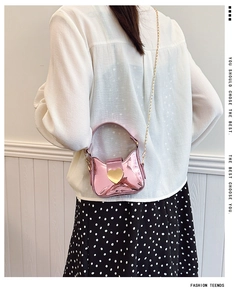 Détail du sac fille en surface laser rose avec boucle coeur dorée et bandoulière chaîne