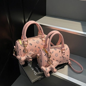 Detail view of pink Boston bags with cute cat prints and textured leather finish