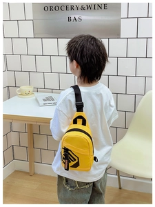 Detail of yellow canvas kids chest bag featuring black geometric patterns and adjustable strap