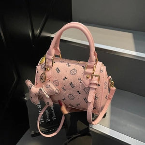 Pink Boston bag detail with cat prints, lychee leather texture, and golden hardware