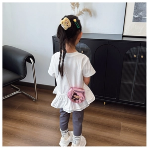 Vista posteriore di una bambina con borsa a tracolla rosa lucida e fiocco in paillettes dorate