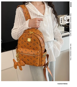 Détail d'un sac à dos marron à motif lychee avec imprimés chat et clous métalliques