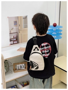 Rear view of white mini chest bag for boys with adjustable strap and orange charm