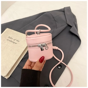Detail of pink mini bucket bag with silver lock zipper on textured faux leather