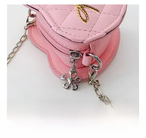 Detailed close-up of smooth silver flower zipper and quilted heart-shaped kids bag