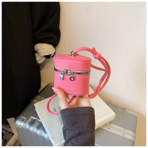 Macro detail of mini pink cylinder bag with lychee texture leather and silver hardware