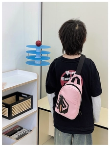 Rear view of a child wearing a pink sporty chest bag with black graphic prints