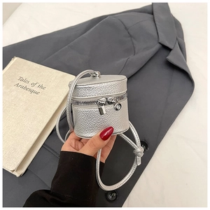 Detail of silver mini cylinder bucket bag showing premium lychee grain texture and zipper