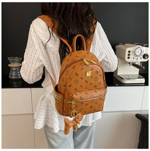 Détails d'un sac à dos marron en PU avec motifs de chats et charme de chien assorti