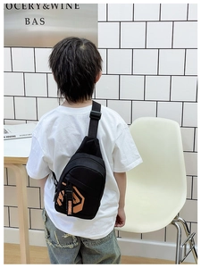 Close-up of black kids crossbody bag with orange logo and adjustable nylon strap