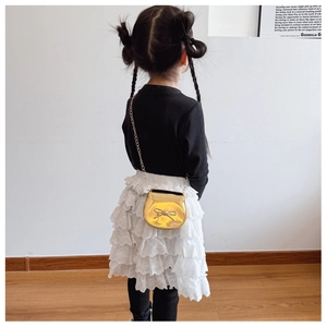 Bimba in top nero con gonna in pizzo bianco e borsa a tracolla dorata con fiocco
