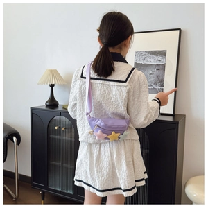 Vue détaillée du dos d'un sac de poitrine violet pour enfant avec étoiles en peluche