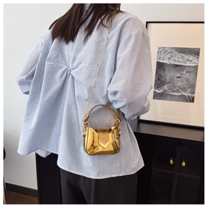 Mini sac à bandoulière doré pour fille avec fermoir cœur et chaîne sur un mannequin