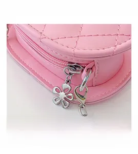 Detail of pink quilted leather bag with silver heart zipper pull and chain strap