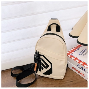 Close-up of cream nylon chest bag with black straps on a wooden table setup