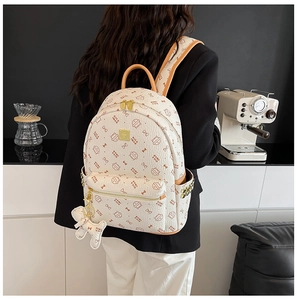 Détail du sac à dos motif chat avec breloque peluche porté par un mannequin dans un café