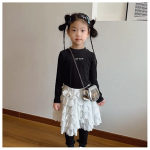 Outfit da bambina con maglietta nera, gonna in pizzo bianco e borsa a tracolla argento