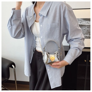 Détail du mini sac argenté brillant avec boucle en métal doré en forme de coeur