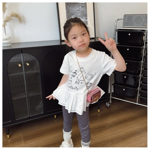 Close-up of white children's t-shirt with cartoon characters and ruffled peplum hem