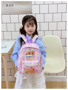 Close-up of purple plaid school backpack with cute cartoon capybara prints on the front