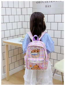 Girl wearing purple plaid backpack with cute cartoon Capybara print in a school setting